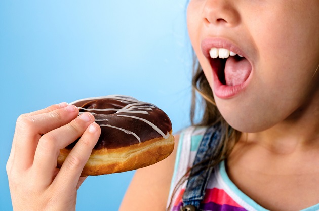Ребенок ест пончик